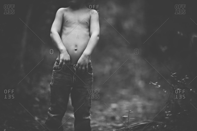 Young boy holding his pants