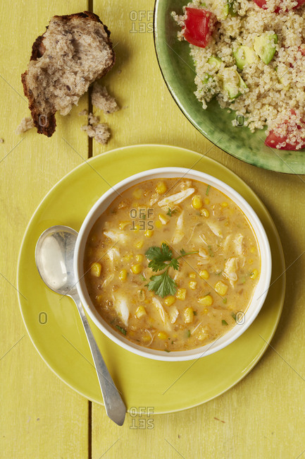 Top view of chicken and sweet corn soup with quinoa salad
