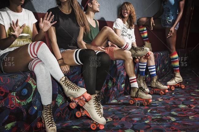Young people sitting on a bench at a roller skate rink