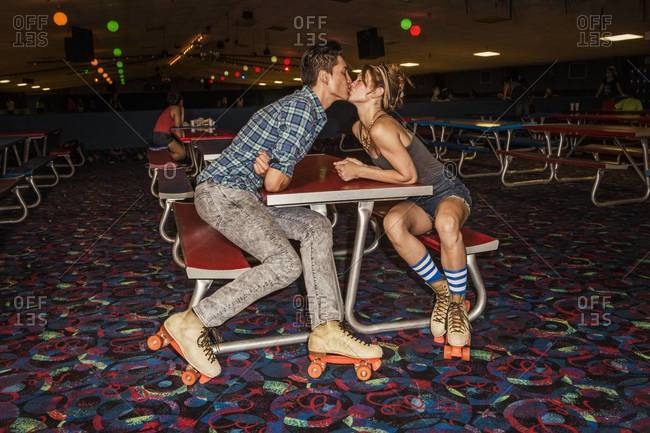 Young couple kissing at a roller skate rink
