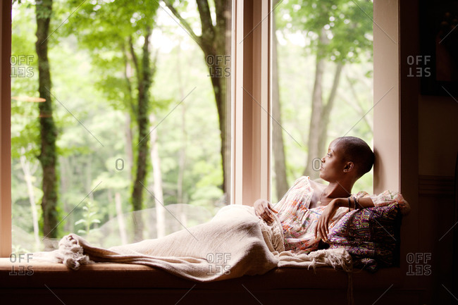 Young woman reclining on window seat