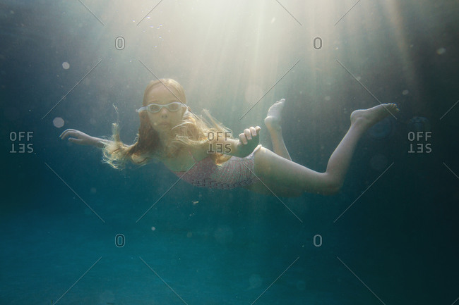 Long haired girl floating underwater
