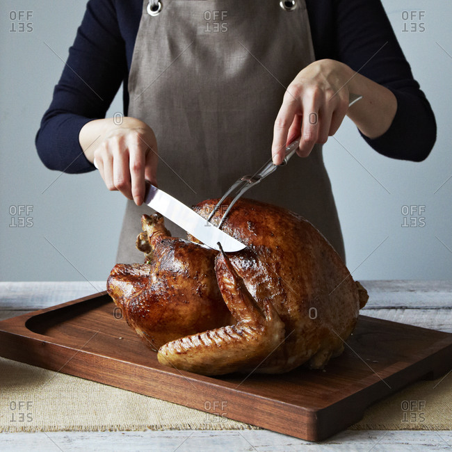 Close up of woman carving a Thanksgiving turkey