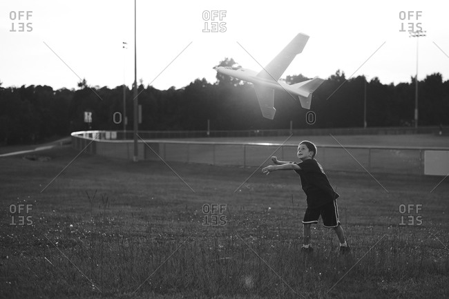 Boy throwing a model airplane in the air