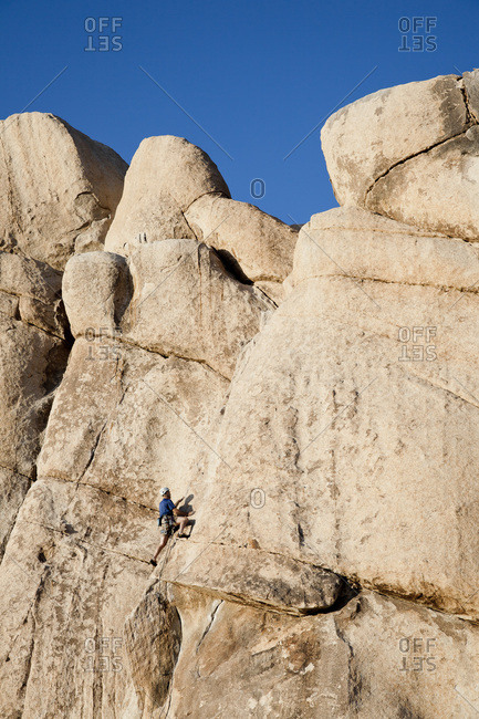 Man climbing a rock in Joshua Tree National Park, California