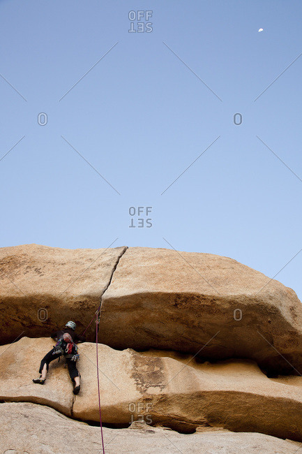 Alpinist climbing a rock in Joshua Tree National Park, California