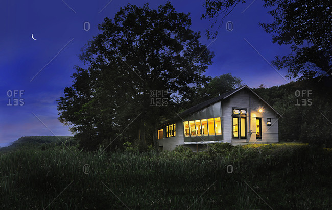 Illuminated cabin with clapboard siding on landscape at night, Burlington, Vermont, USA