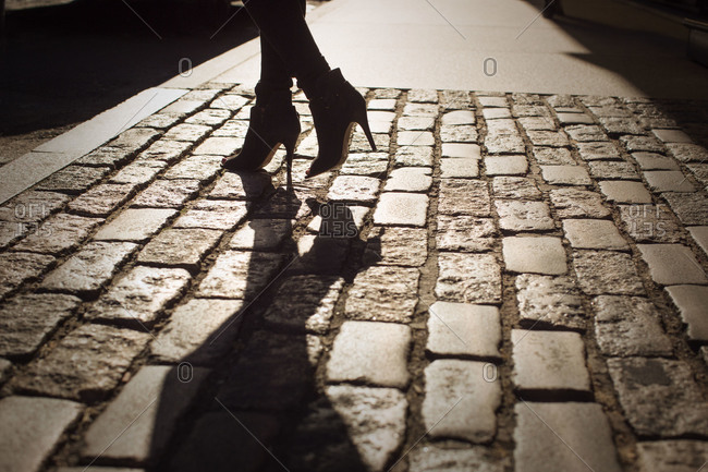 Woman\'s feet in high heels on the sidewalk
