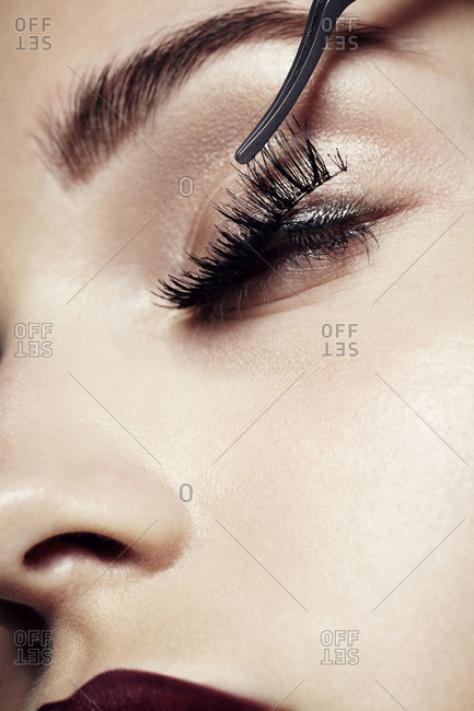 Woman applying false eyelash