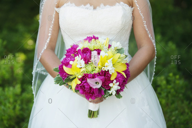 Midsection view of bride holding a bouquet