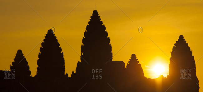 The sun rising behind the towers of Angkor Wat temple complex, Cambodia