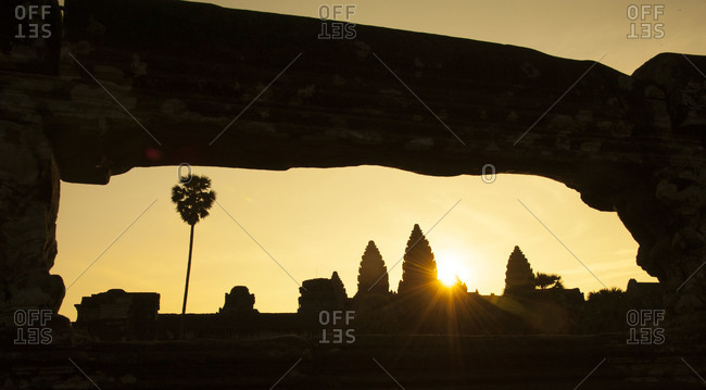 The sun rising behind the towers of Angkor Wat temple complex, Cambodia