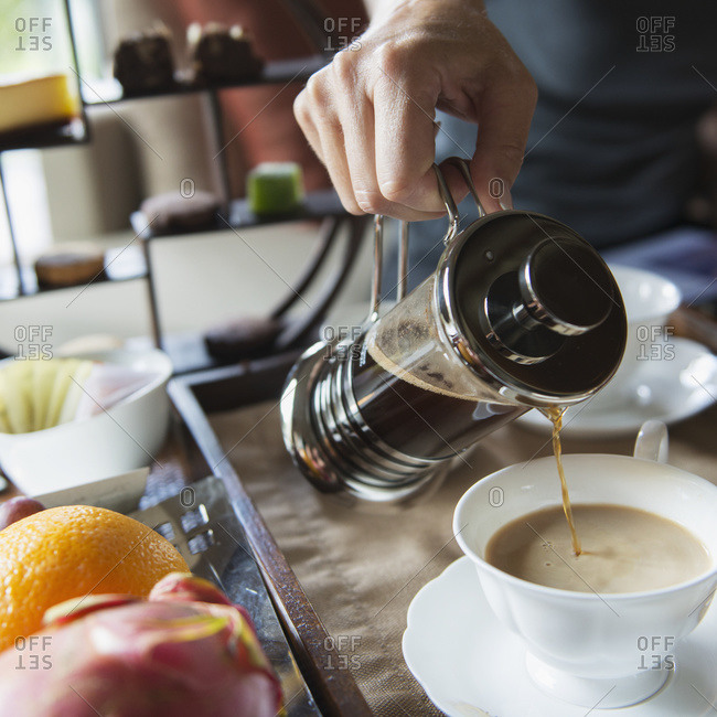Man pouring coffee into a cup from a coffee press