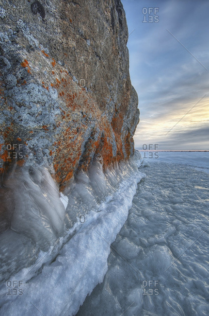 Large lichen covered rock in a frozen lake situated on the flats beside Hudson\'s bay