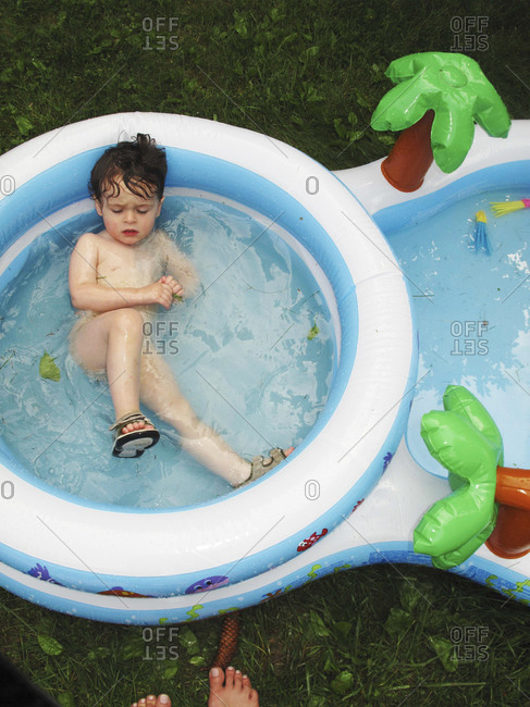 Young boy resting in a kiddie pool