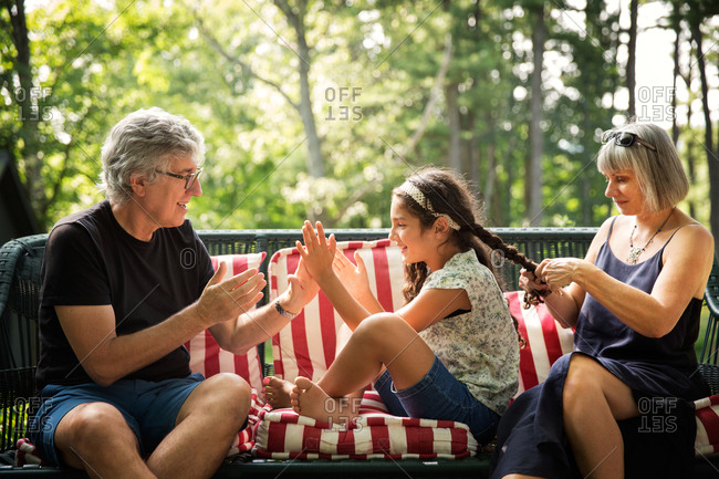 Elderly man playing a clapping game with his granddaughter