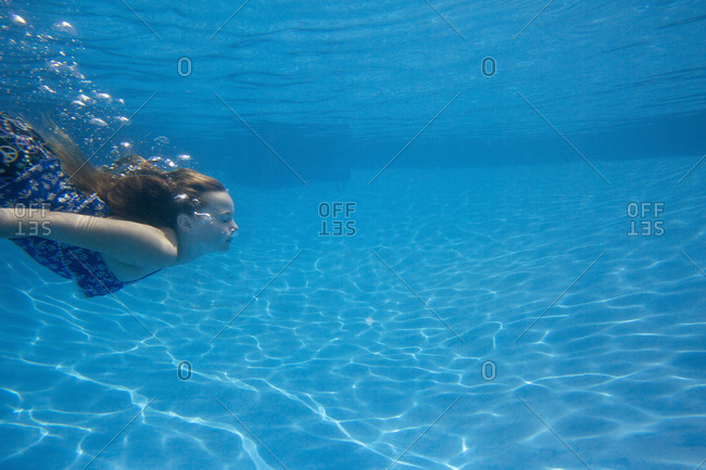 Girl diving under water in a swimming pool