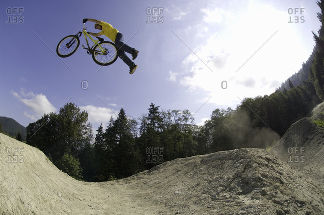 Man performing a mountain bike stunt on a track
