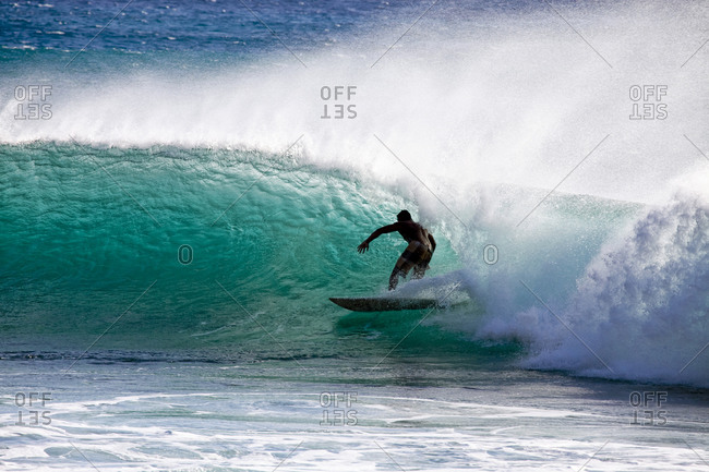 Man surfing in an ocean wave tube