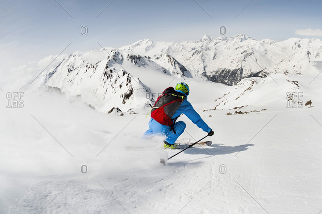 Man skier skiing downhill steep slope mountains