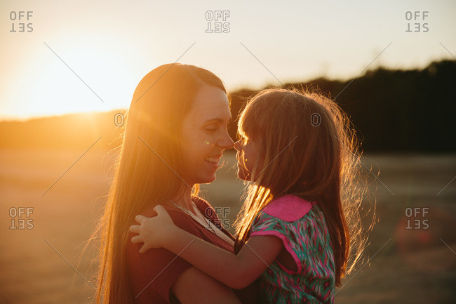 Woman and young girl touch noses