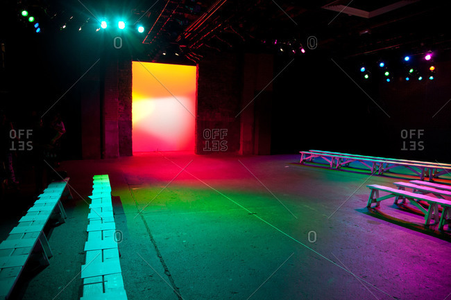Colorful lights illuminating an empty runway at a fashion show