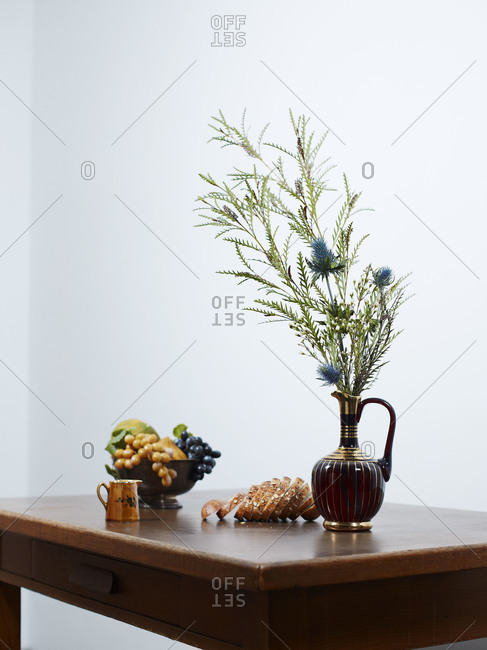 Still life of a flower bouquet with fruits and bread on a table