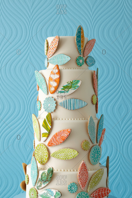 Abstract leaves decorate a white four-tiered cake