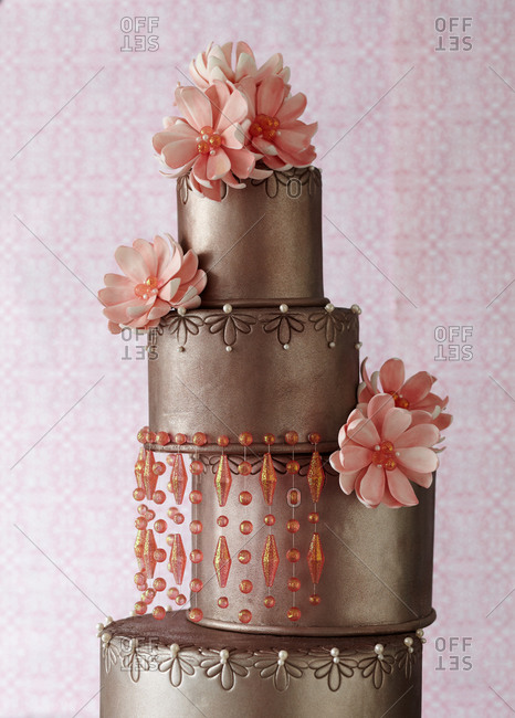 Pink flowers decorate a four-tiered cake - Stock Image - Everypixel