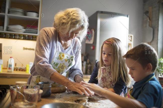 Grandmother making food with grandchildren