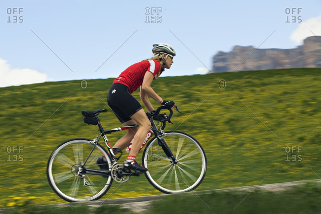 A woman road biking in Italy