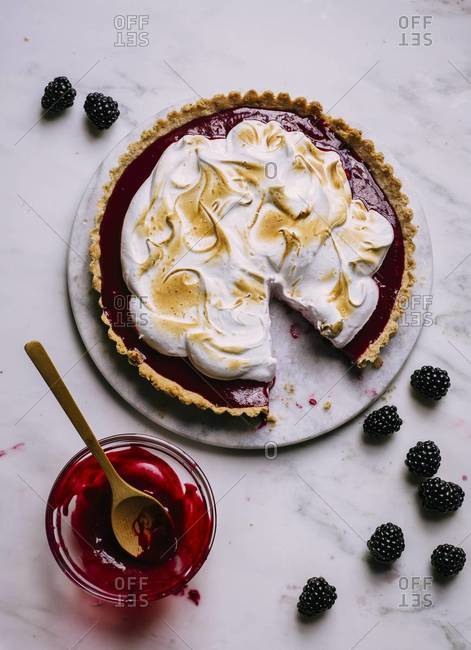 Top view of a blackberry curd tart topped with meringue