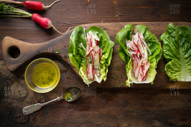 Gem lettuce with radish on a cutting board