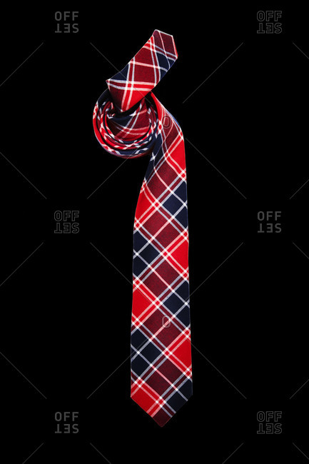 Red and blue plaid tie on black background