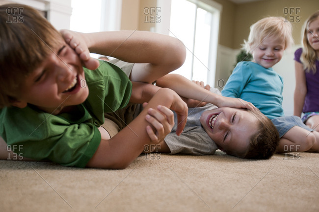 Children play fighting on floor
