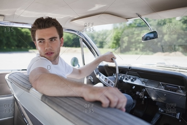 Young man in vintage car