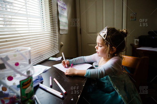 Girl drawing with markers in princess dress