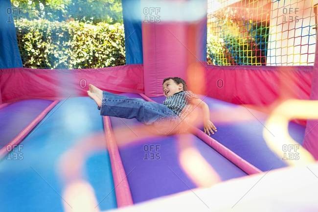 Boy falling midair in bouncy castle