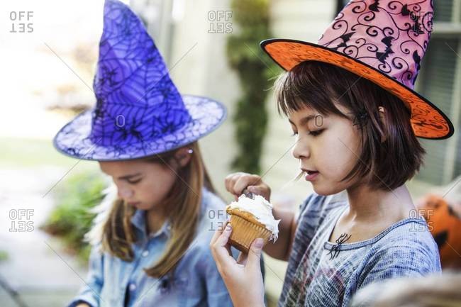 Young girl eating a cupcake on Halloween