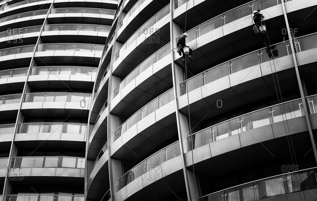 Two men cleaning the facade of a building