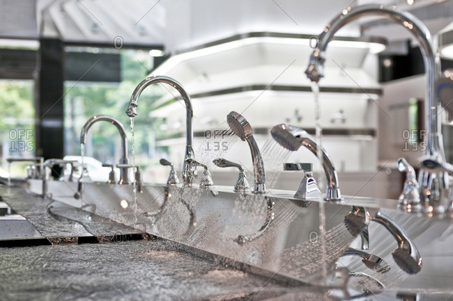 Faucets with running water on in kitchen and bath showroom