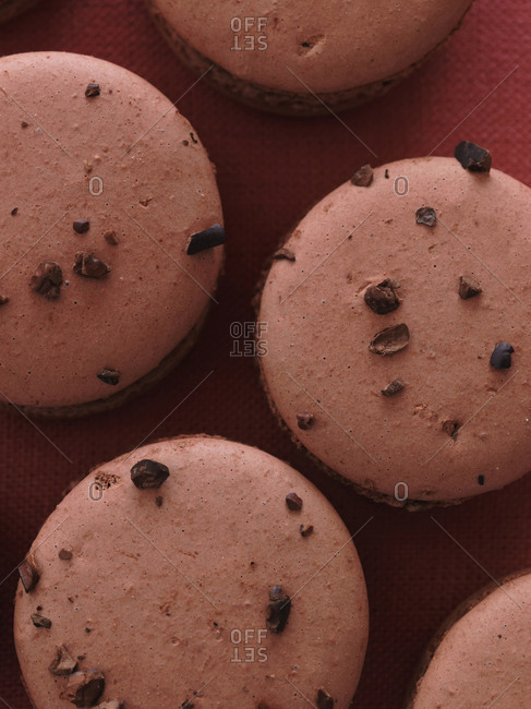 Macarons with sprinkles on pink background from above