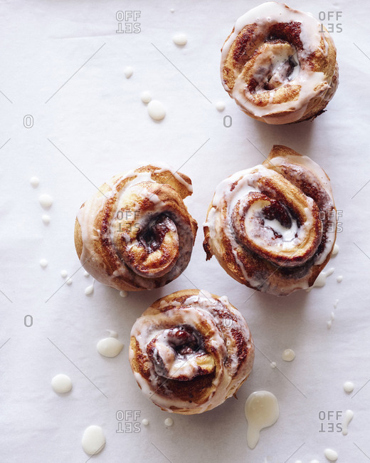 Four cinnamon rolls on white background from above