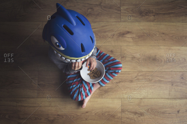 Young boy eating cookies in a shark helmet