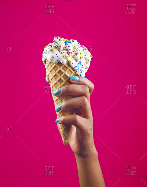 Woman holding meting ice cream sprinkled with jimmies