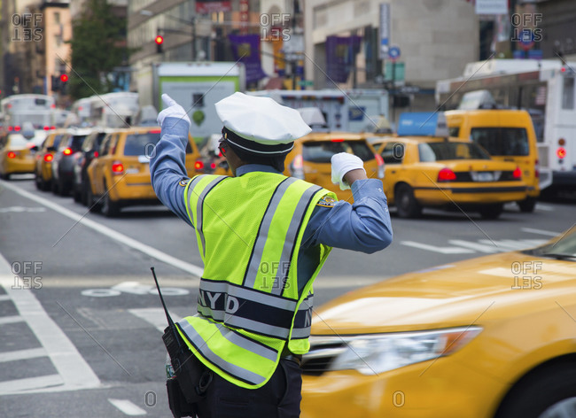 A traffic cop points down the street