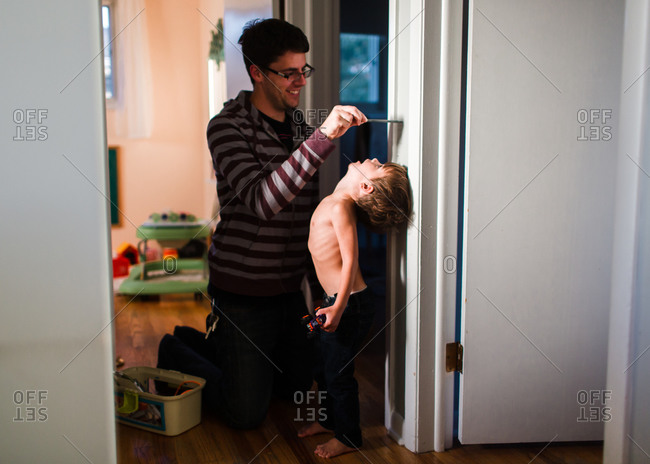 Father measuring son in  doorway
