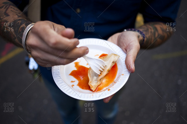 Man eating street food on plastic plate