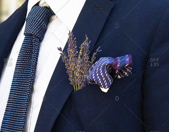 A man wears a pocket square and flowers in his suit