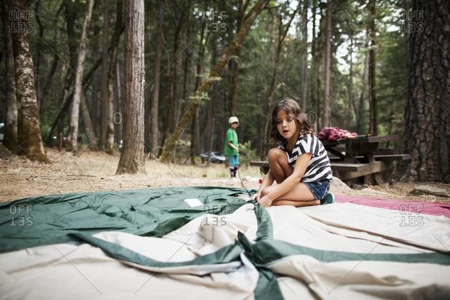 Little girl trying to set up a tent